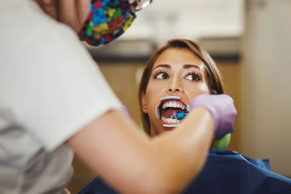 美しい若い女性のショットは 歯科医です 歯医者の椅子に座り歯の上に歯を食いしばり — ストック写真