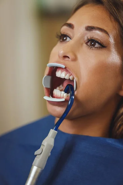 美しい若い女性の切り取られたショットは歯科医にあります 歯の上にブレースをセットする準備をしている歯科医の椅子に座り — ストック写真