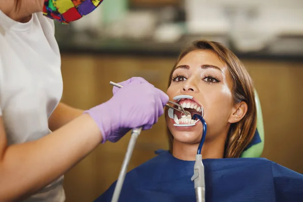 美しい若い女性のショットは 歯科医です 歯の上にブレースをセットする準備をしている歯科医の椅子に座り — ストック写真