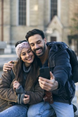 Yeni şehirde selfie çeken gülümseyen turist çift birlikte keşfe çıkıyorlar..