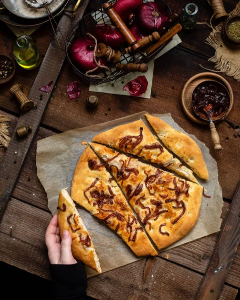 Overhead shot of baked homemade focaccia or pizza with caramelized onion