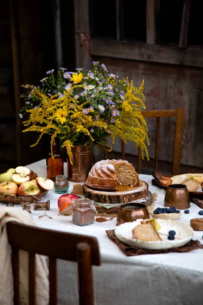 beautiful outdoor still life in country garden with bundt cake on wooden stand on rustic table