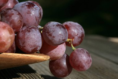 Eski, bir ülke ev ahşap bir masa üzerinde asılı üzüm demet. Yaz sonunda bir hasat festival vesilesiyle açık dekorasyon unsuru.