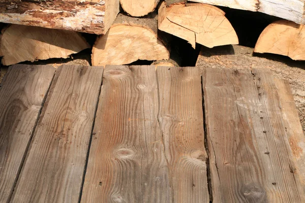 Пустой Деревянный Стол Палубе Кучей Дров Заднем Плане — стоковое фото