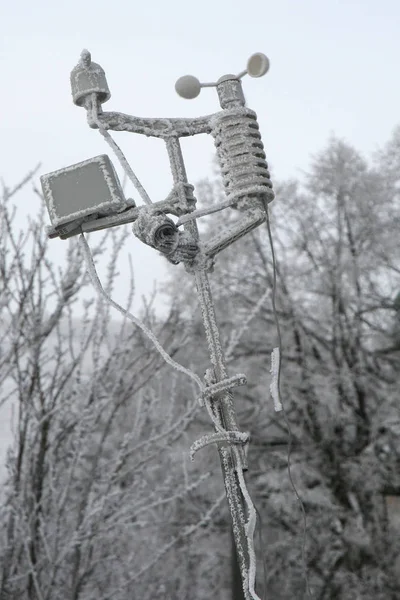 Small, home weather station, with a weather monitoring system in country garden by winter.