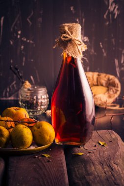 Şişe likörü Ayva tentür malzemelerle ahşap bir masa üzerinde
