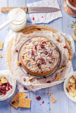 Lezzetli muzlu kek ile fındık, susam ve kızılcık mavi ahşap bir masa üzerinde.