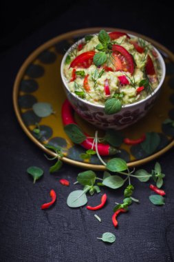 Bir kase guacamole domates, biber biber, kireç, soğan, sarımsak, dereotu ve kekik ile