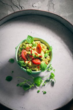 Bir kase guacamole domates, biber biber, kireç, soğan, sarımsak, dereotu ve kekik ile