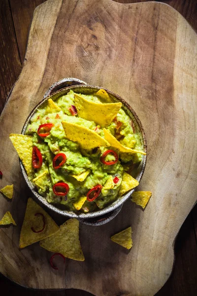 Kom guacamole maïs chips houten tafel — Stockfoto