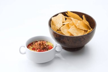 Beyaz arka planda siyah fasulye çorbası ve mısır cipsi görünümü kadar kapatın.