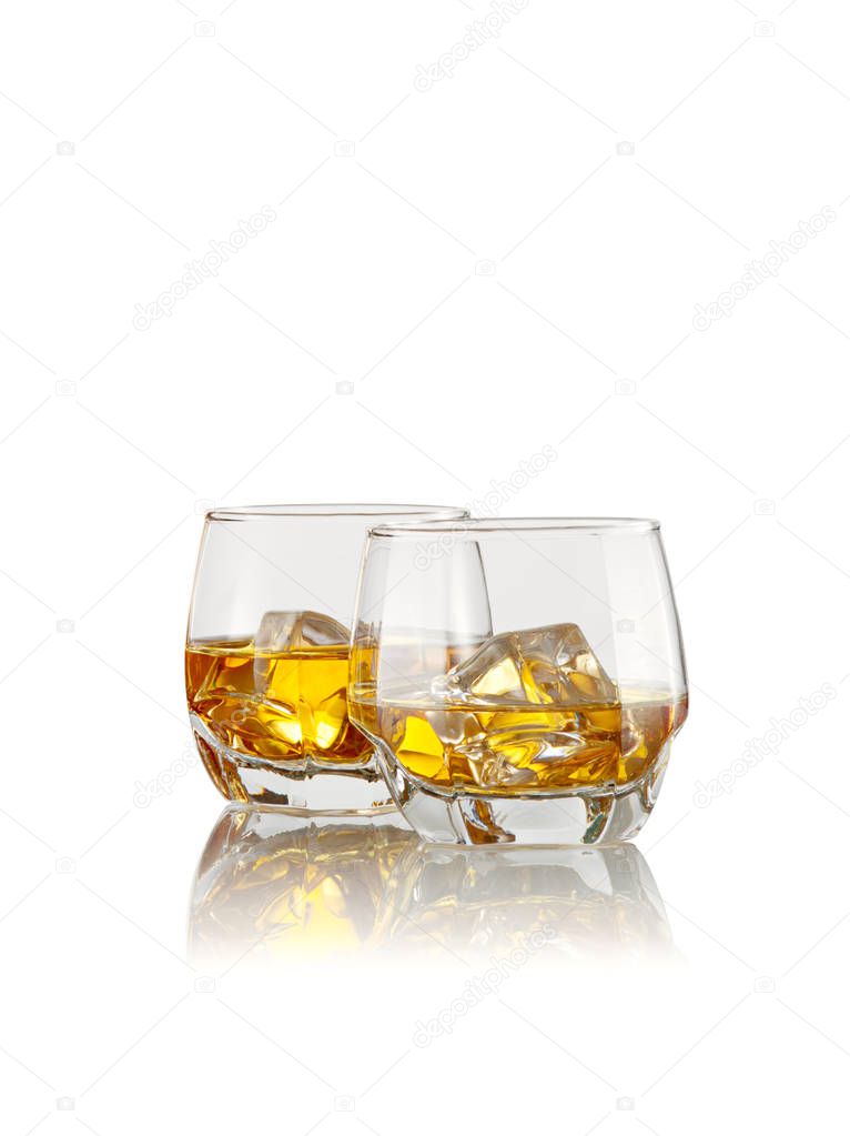 close up view of two glasses with ice and whiskey on white  background