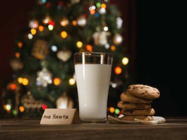 close up view of glass of milk with cookies on color back clipart