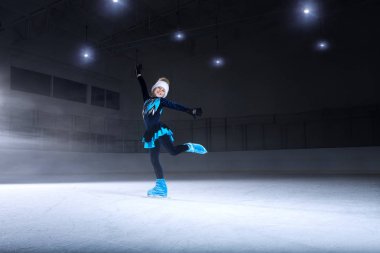 Koyu buz arenasında çocuk artistik patinajcının görünümü