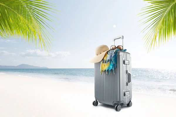 在阳光明媚的热带海滩上可以看到带帽子 帕雷奥和太阳镜的手提箱 — 图库照片
