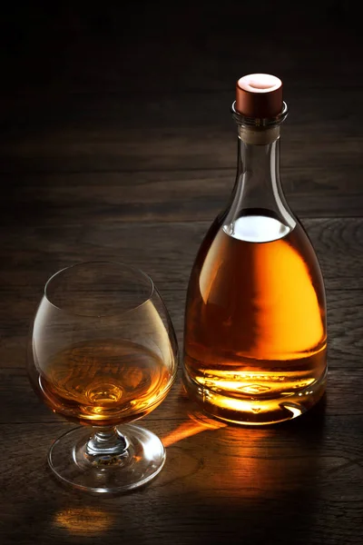 View Glass Cognac Bottle Aside Color Wooden Background — Stock Photo, Image
