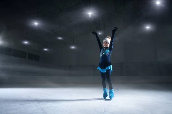暗い氷のアリーナを背景にした子供フィギュアスケート選手の見解 — ストック写真