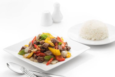 Kızarmış bifteğin beyaz sırtında kesilmiş sebzeli görüntüsünü kapatın.