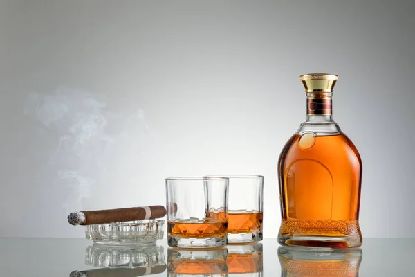 Close Zicht Sigaar Fles Cognac Een Bril Opzij Grijze Rug — Stockfoto