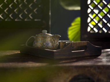 Güzel porselen çaydanlığın ve renkli bardakların yakın görüntüsü.