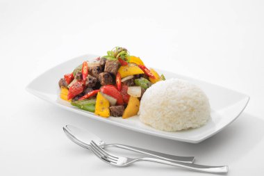 Kızarmış bifteğin beyaz sırtında kesilmiş sebzeli görüntüsünü kapatın.