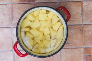 bir tencerede ham, soyulmuş ve kesilmiş patates