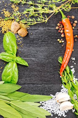 Kokulu yaprakları, adaçayı, fesleğen ve kekik, tuz, küçük Hindistan cevizi, hardal tohumu ve sarımsak, bezelye ve acı biber ahşap tahta arka plan üzerinde çerçeve