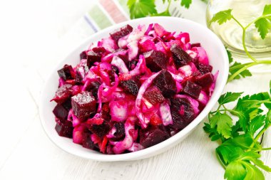 Salata salata turşusu ile veya lahana, patates, pancar ve soğan, bitkisel yağ bir kase, peçete, maydanoz bir ahşap tahta arka plan ile terbiyeli