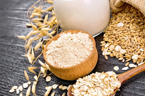 Flour oat in bowl with oatmeal on wooden board — Stock Photo, Image