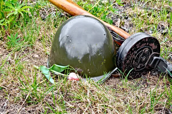Шолом і кулемет з тюльпаном на траві — стокове фото