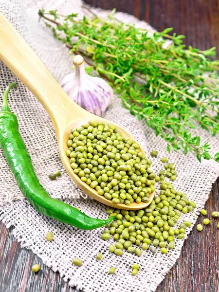 Mung beans in spoon on dark board — Stock Photo, Image