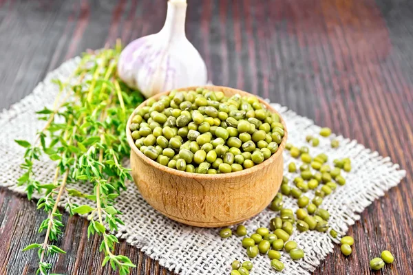 Haricots mungo dans un bol en bois avec thym sur la table — Photo