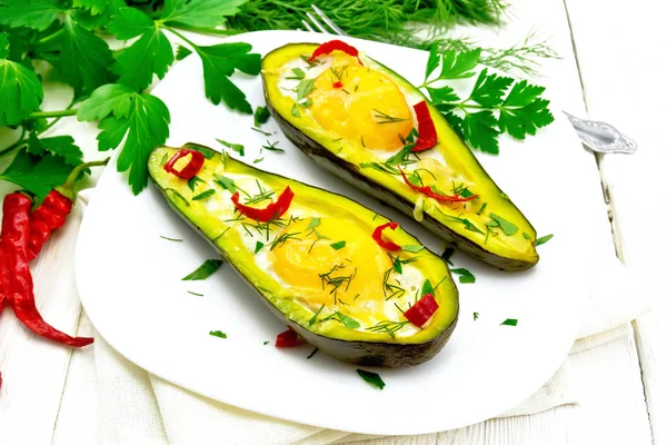 Яичница с перцем в авокадо на светлой доске — стоковое фото