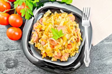 Gemide siyah tabakta sosis ile lahana güveç