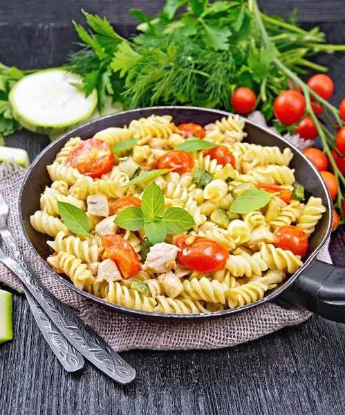 Fusilli with chicken and tomatoes in pan on burlap — Stock Photo, Image