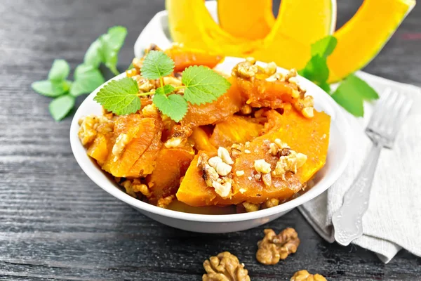 Calabaza con nueces y miel sobre tabla de madera negra —  Fotos de Stock