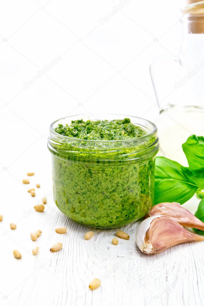 Pesto in glass jar on white board