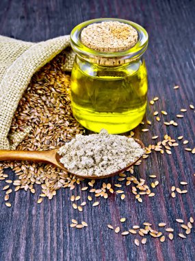 Koyu tahta üzerinde tohum ve yağ ile kaşıkta un keten