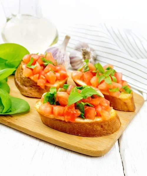 Bruschetta com tomate e espinafre na mesa de madeira leve — Fotografia de Stock