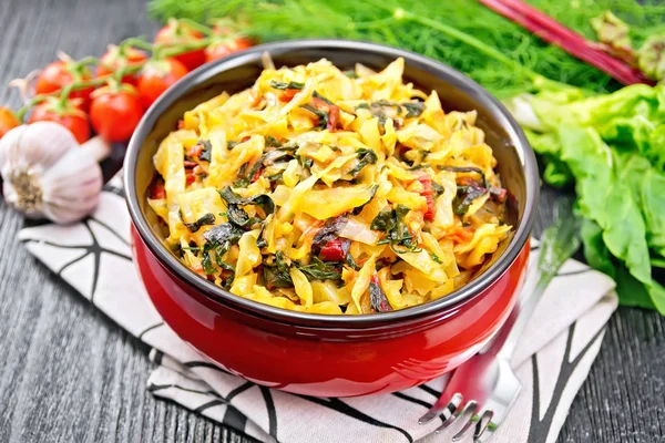 Cabbage stew with chard in bowl on dark board — Stock Photo, Image