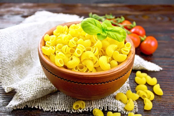 Macarrão de cotovelo em tigela com tomate e manjericão a bordo — Fotografia de Stock