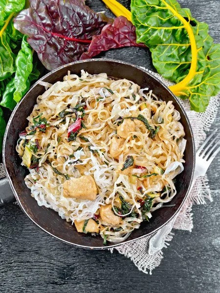 Funchoza with chard and meat in pan on black board top — Stock Photo, Image