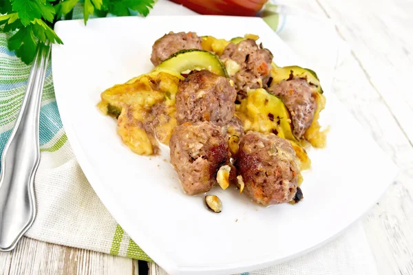 Boulettes de viande avec courgettes et noix dans une assiette sur panneau lumineux — Photo