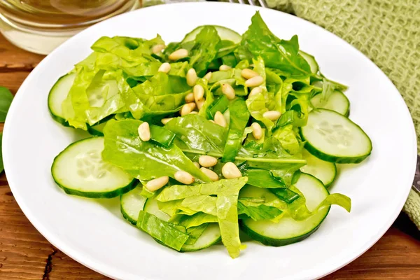 Salad from spinach and cucumber with napkin on wooden board — Stock Photo, Image