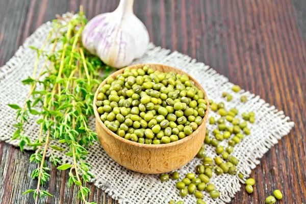 Mung beans in wooden bowl with thyme on dark board — Stock Photo, Image