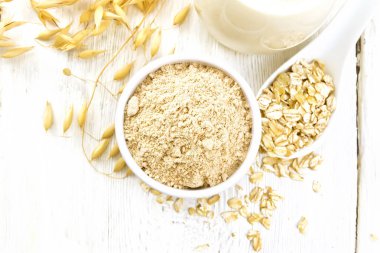 Sütlü kase içinde un, beyaz tahta üstünde.