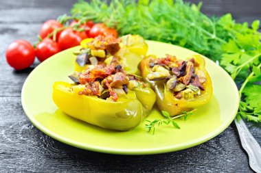 Siyah tahtada yeşil tabakta sebzelerle doldurulmuş biber.