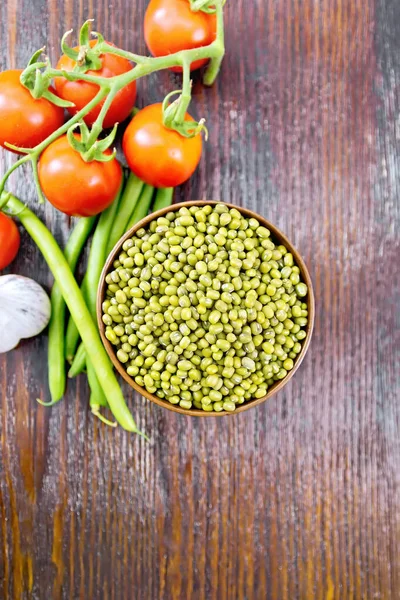 ダークボード上の野菜とボウルに豆をムンベース — ストック写真