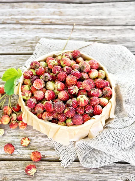 Erdbeeren in Schachtel auf altem Holzbrett — Stockfoto