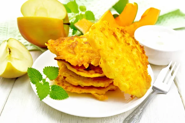 Panqueques de calabaza con manzana en plato sobre pizarra blanca — Foto de Stock